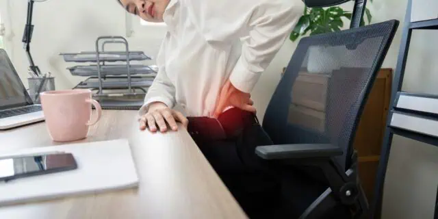Professional Experiencing Back Pain At Office Desk Workplace Health And Ergonomic